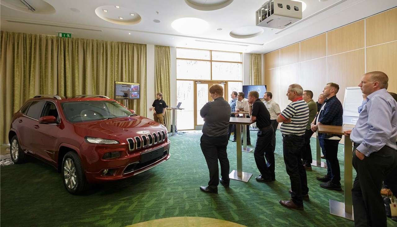 Group looking at a red Jeep car