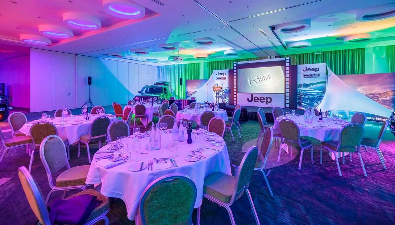 Room set up for evening event with screen for presentation