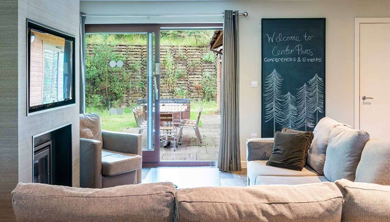 Lounge area with chalk board saying ' Welcome to Center Parcs Conferences and Events'.