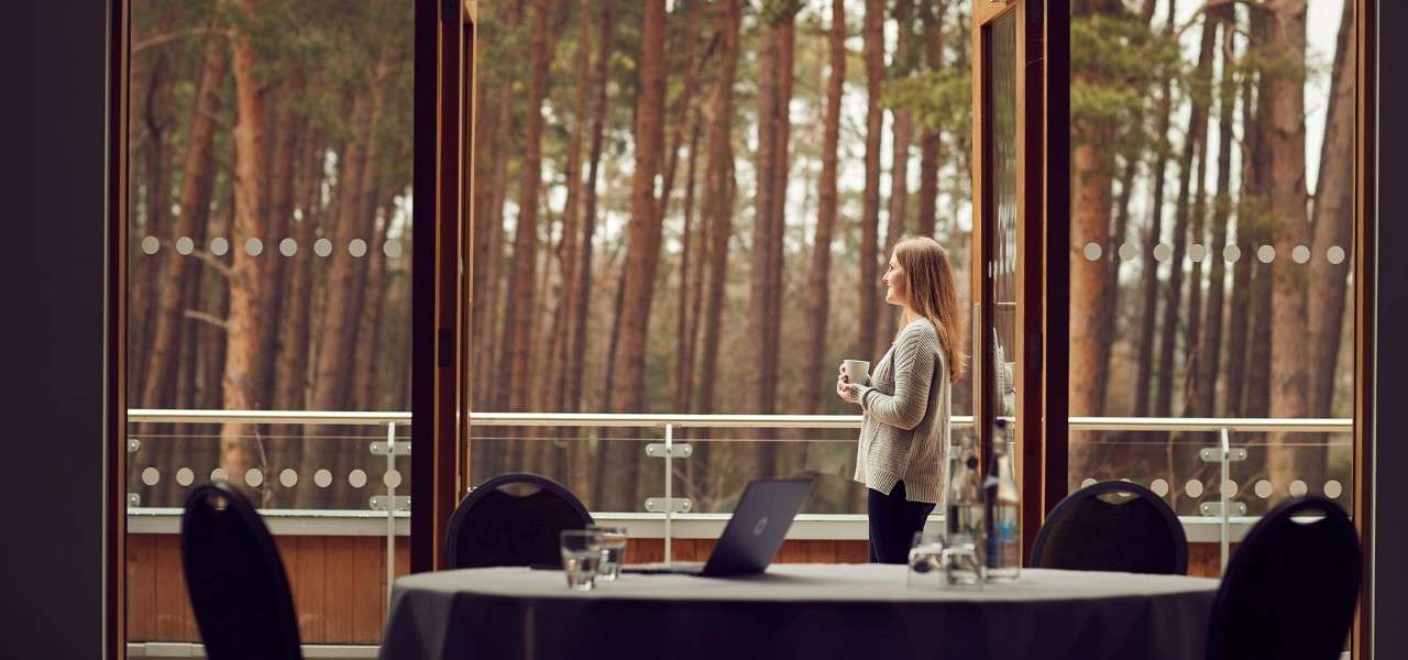 Woman looking over a balcony in the forest