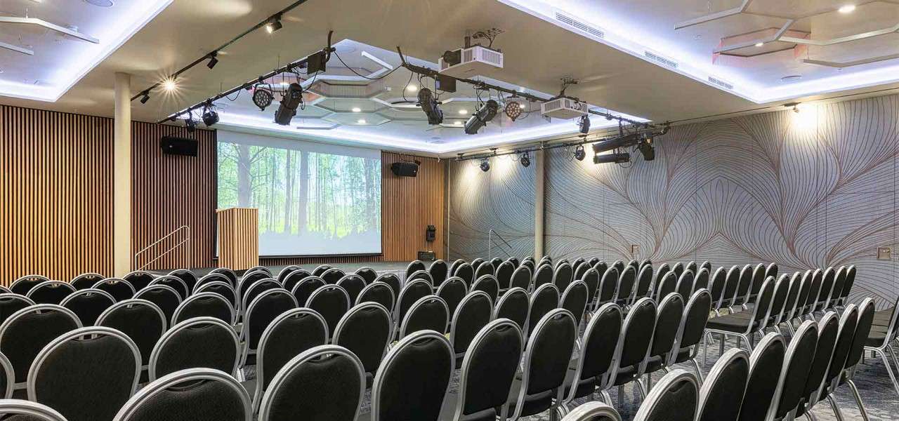 Conference room set up with chairs in rows in front of a projector.