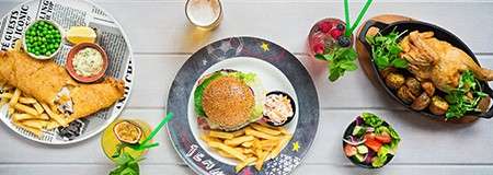 A selection of meals including fish chips and peas, a burger ad chips and a roast chicken