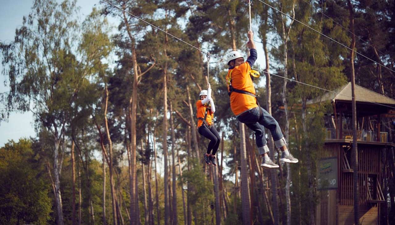Two people going across a zip line