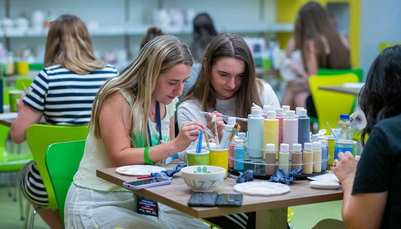 Delegates doing pottery painting.