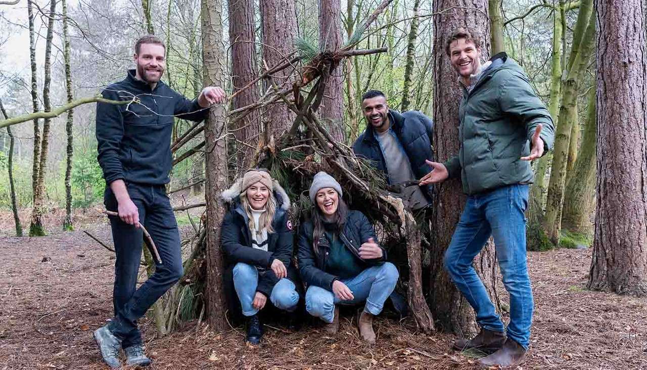 Delegates building a den in the forest.