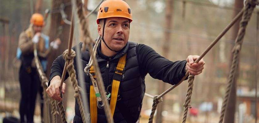 Man aerial adventure activity high in the trees