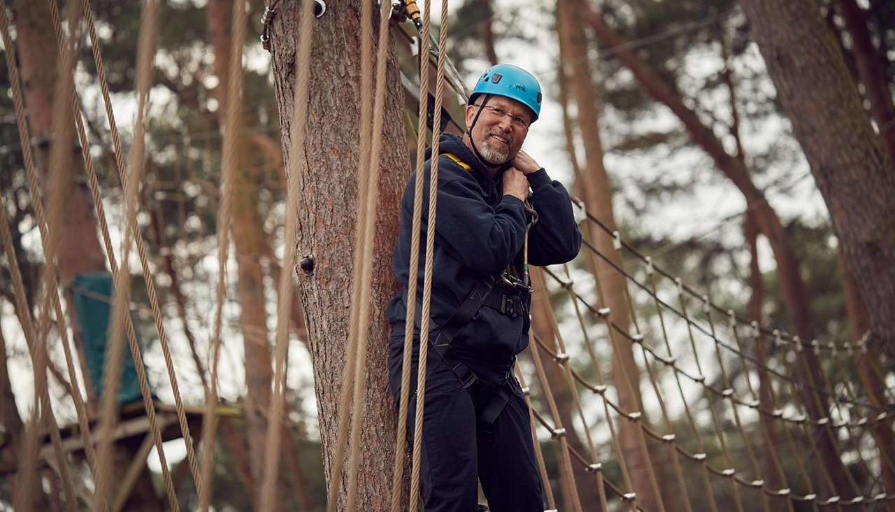 Man stood on a platform up in the trees