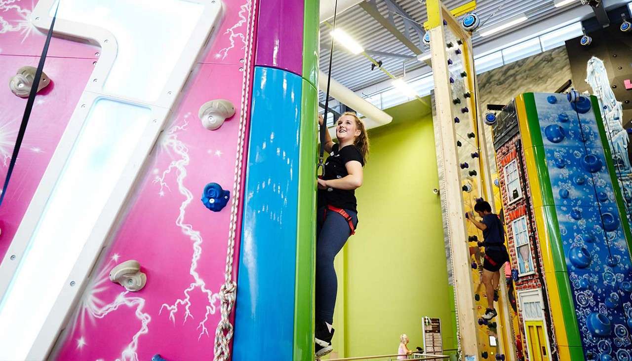 Woman climbing up the climbing wall