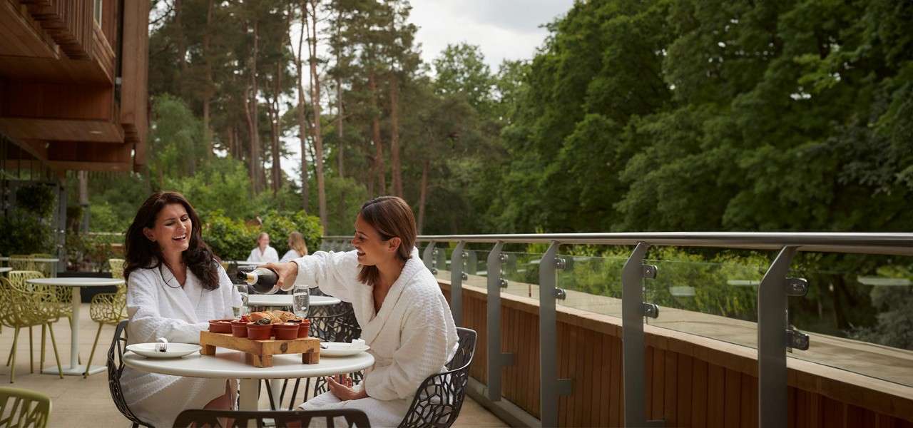 Two women on the outdoor terrace having lunch.