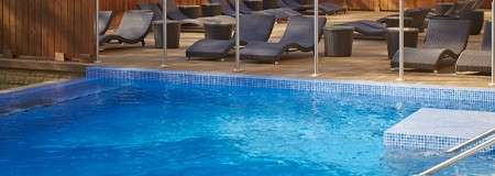 Bubbling outdoor pool surrounded by sun loungers.