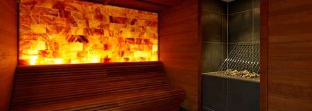 Glowing salt wall behind wooden seating.